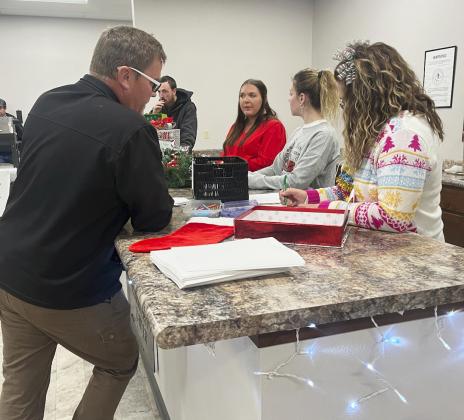 Mike Kvanvig watches as Jennifer Peters checks over his trivia answers during the Walkabout at the Hooker County Community Center. The winner of the trivia was Erin Cox. Ashlyn Simonson won the Ugly Sweater Contest. They both won $50 from the Mullen Commercial Club. Gerri Peterson