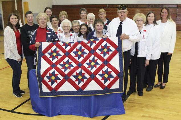 American Legion Auxiliary and Junior Auxiliary members are pictured with Marvin Cox and the Quilt of Valor made by Auxiliary member Doris Starr after the Memorial Day program on Monday. Pictured l-r: Rebekah Peters, Carol Wright, Doris Starr, Alysen Daniels, Jan Furrow, Mildred Szwanek, Winnie Cooley, Sherron Sullivan, Eva Crawford, Kalli Licking, Alice Phipps, Linda Cox, Kathie Hassett, Marvin Cox, Kathy Tuton, Kristi Daniels, Sue Licking. Gerri Peterson