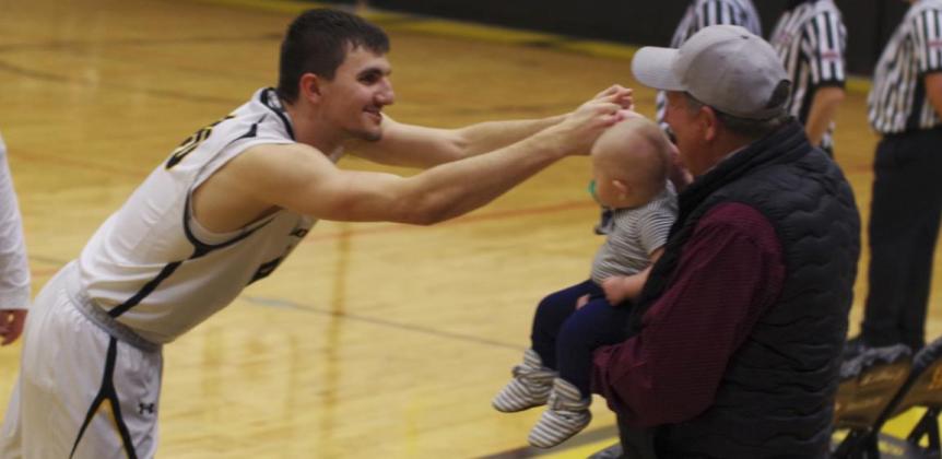 Senior Bryce McIntosh fist bumps his nephew, Chasin McIntosh, held by Bryce’s dad, Bernie, last week on Senior Night. Barb McIntosh