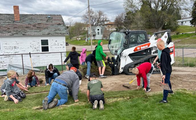 The Mullen High School track team helped Rich Burrious lay sod, and Rich then donated the extra sod to the Mullen Elementary School. Pictured are Mrs. Rice, Mr. Ewoldt and the fifth graders helping to lay the elementary sod on Friday, May 3. Brett Mauler
