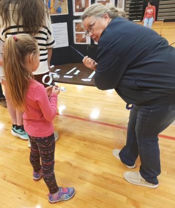 Anna Baum helps Brogan Jewell make an airplane at Up, Up and Away