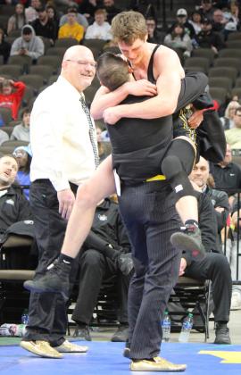 Chase Gracey celebrates his gold medal at State Wrestling with Assistant Coach Bo Pettit as Head Coach Russ Monette looks on. Kris Forsen