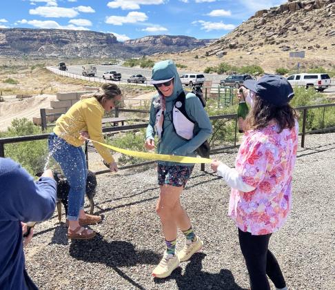courtesy photos Madison Tomlinson crosses her finish line with a champagne spray to be the first person to pioneer and complete a continuous loop around Colorado’s Grand Valley earlier this month.