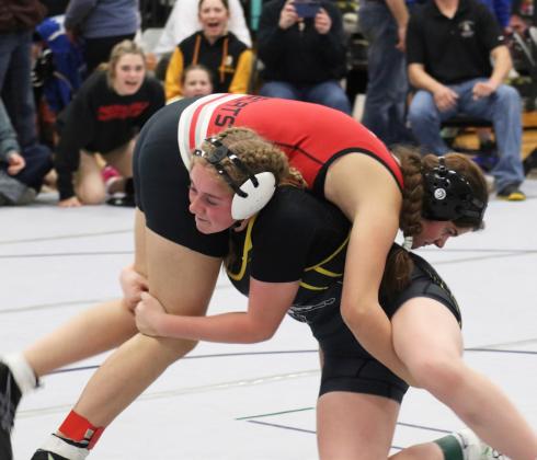Kassidy Cheever competing in Oshkosh with her teammates cheering her on in the background. Joni Cheever