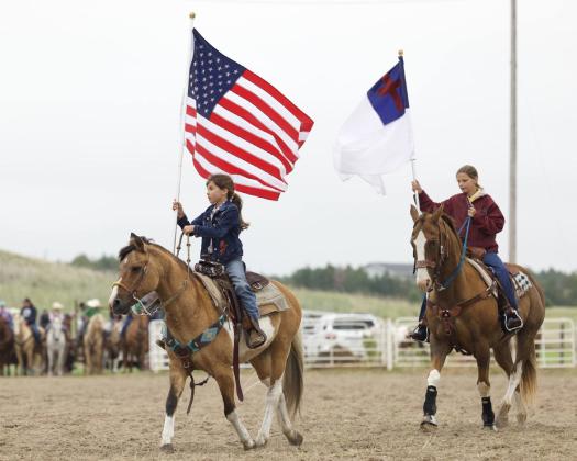 Mullen’s Finley Mundorf carries the American flag in the grand entry for the Sandhills Rodeo Bible Camp. Suzie Wahlgren