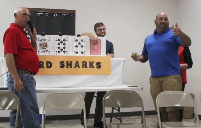 Casey Phillips (right) looks to the crowd to help him decide if the next playing card is higher or lower in Card Sharks Saturday night. MCs Ron Boyer and Ty Kvanvig are also pictured. Gerri Peterson