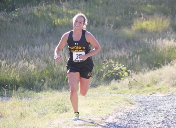 Callie Coble grins as she is cheered on coming up a hill on the Bridgeport course. Alex Moore