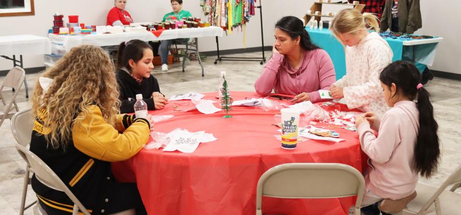 Riley Hegland, Luciana Gonzalez, Lorena Mercado, Danielle Peterson and Abigail Gonzalez work on building Christmas ornaments from Sandhill Fertilizer’s table at the Hooker County Community Center during Walkabout.