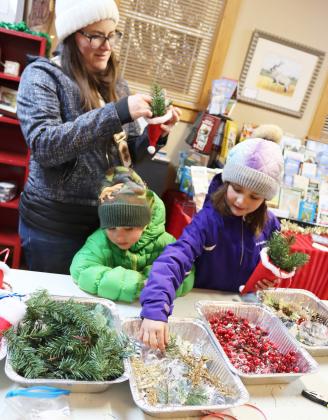 Levi and Ellie Licking pick out items for their stocking craft at the Mullen Arts Center during the Walkabout last Friday, Dec. 13 with their mom Harley’s help.