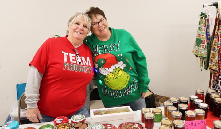 Sisters Chris Sittler and Pam Coons at their table during the Walkabout selling Tupperware, jelly, aprons and more.