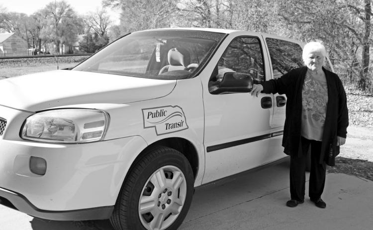 In this photo from 2015, Darlene Osborn stands next to one of the vans she drives for Hooker County Transit. Osborn is still a driver, along with Artis Hicks. file photo