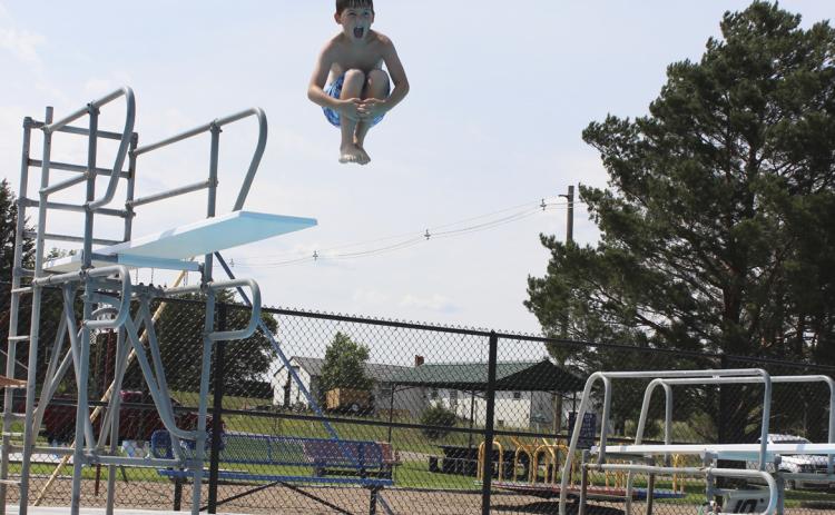 Zach Hicks lets out a shout as he jumps into the water during the biggest splash off of the high board at the Water Carnival. Gerri Peterson