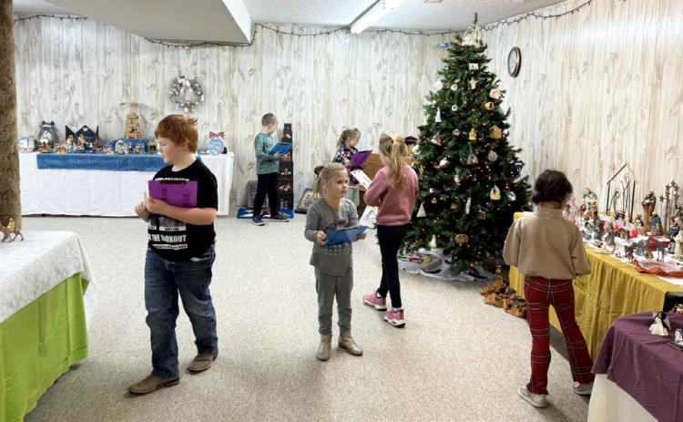 With clipboards in hand, elementary students search for specific items amongst the nativities last week. Roxann Brown