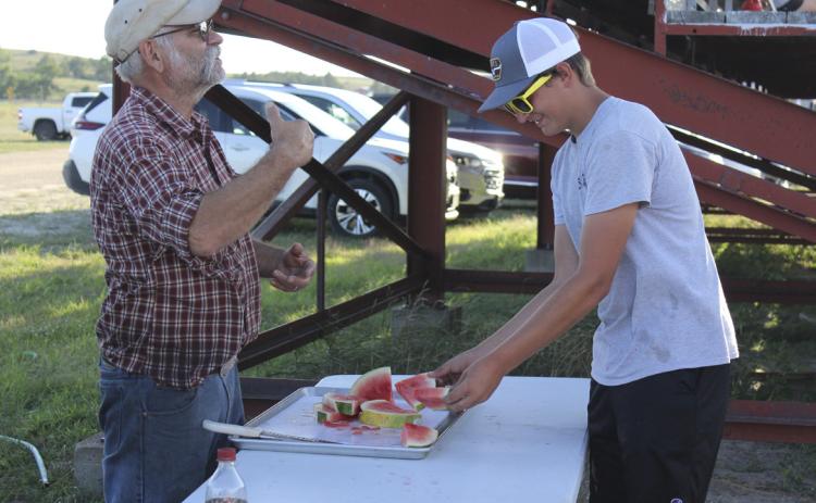 A secret business owner “Fair Santa” donated all of the watermelon that was enjoyed by everyone at the fair events. Chuckwagon ‘n Jug’s Gregg and Dawn Mallory helped serve them. Here Gregg tells fair-goers at the Redneck Hunger Games that they have two hands, therefore they need two pieces of watermelon! Gerri Peterson