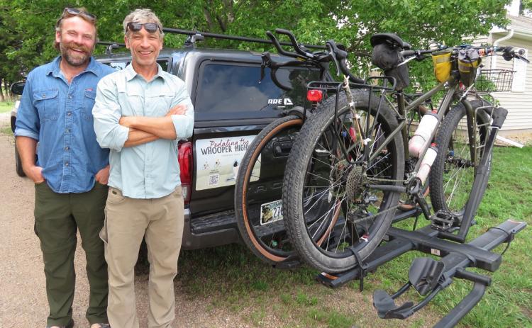 A pickup carrying water, food, other supplies and at least one support person drives with Andy Caven (left) and Mike Forsberg, pictured at Rowe Sanctuary, on their 2,500-mile bike ride from south Texas to northern Saskatchewan. Their bicycles are designed for gravel roads and 'bikepacking.' Lori Potter