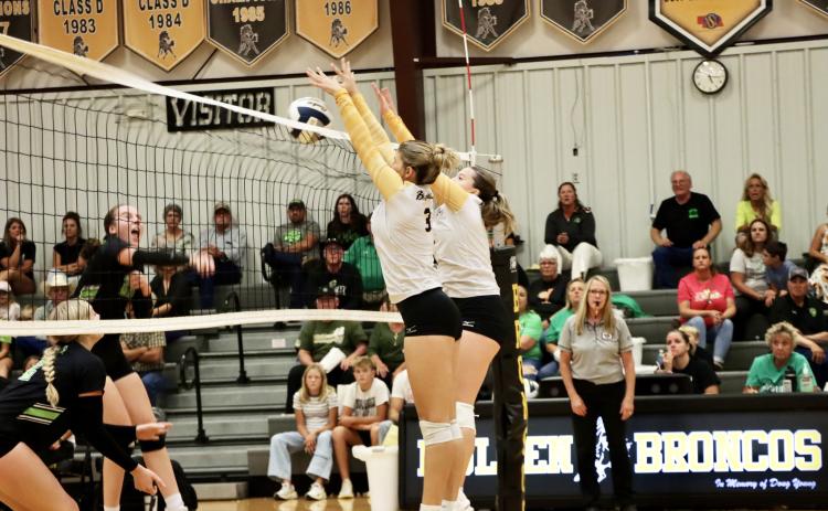Seniors Medora DeNaeyer and Izzy Hoyt go up with the double block last week against Maywood-Hayes Center.
