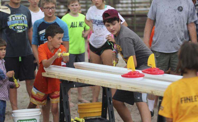 Brandt Mundorf (left) and Jaylon Forsen compete in the Rain Gutter Boat Race during the Redneck Hunger Games. Gerri Peterson