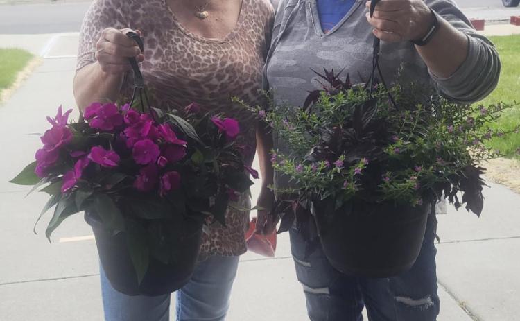 Chris Sittler (left) and Pam Coons with the flowers that they brought up for residents to enjoy.
