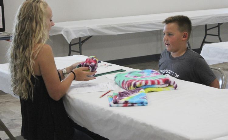 Carson Hegland explains to one of the 4-H judges how he made his tie-dyed items. Gerri Peterson