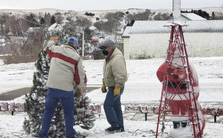 Teamwork makes the dream work. The Christmas tree and Santa did not do well with the storm last week. Willard Boyer and Darrell Leibhart get it all set back up.