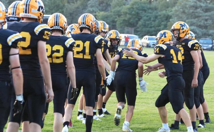 The Broncos cheer on each other as the starters run through a tunnel of their teammates as they are announced last Friday night. Carolee Brown Photography