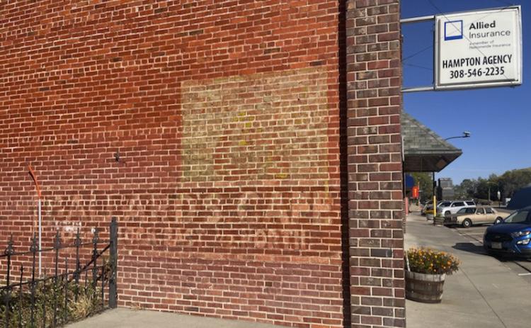 The sign on the west side of the downtown Mullen Hampton Building with directions to the Ballard Cafe is faded but still visible today.