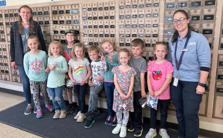 The kindergarten class visited the Mullen Post Office on May 2, where they mailed letters and learned about the mailing process. Pictured l-r: Kindergarten teacher Leanne DeKay, Brogan Jewell, Charlotte Connealy, Kayden Evans, Meyer Vinton, Jaxson Barnes, Anna Ridenour, Aurora Polt, Tate Phillips, Kinley Crisp and Brandi Kearns. Judy Mulligan
