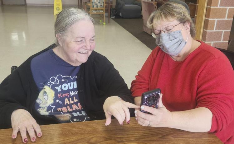 Ann Connell enjoying pictures of Vicky Earl’s grandson.