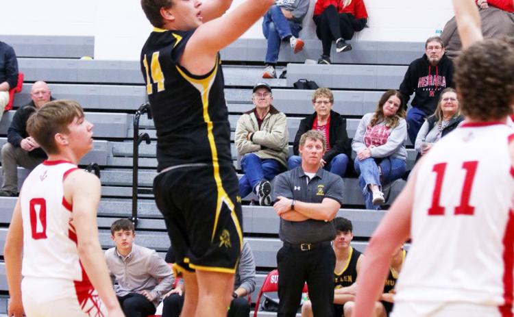Jacob Walker puts up a shot at Sutherland, while Head Coach Brad Wright looks on from the bench. Carolee Brown Photography