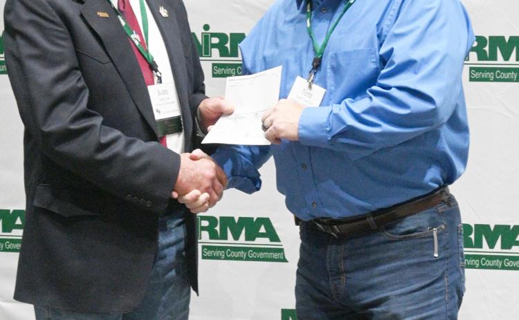 NIRMA Board of Directors Member R. Buddy Small (left) presents a dividend check to Hooker County Sheriff Todd Yost. courtesy photo