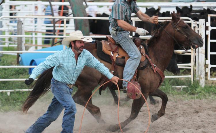Left: Brett Phipps runs to help the rest of his teammates load the trailer, while Ty Kenner races to drop the chalk in the bucket from their branding.