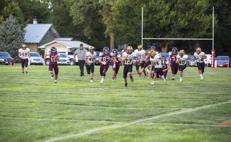 Quarterback Chase Gracey sprints down the field with his teammates and the Twin Loup team in hot pursuit. Jadyn Andersen