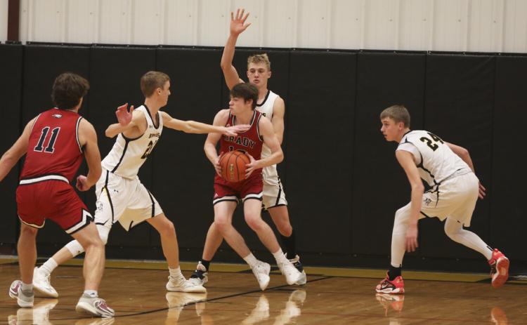 A Brady player is surrounded by Moores - brothers Alex and Kaleb Moore on the left and right, and their cousin Clayton behind him. Megan Andersen