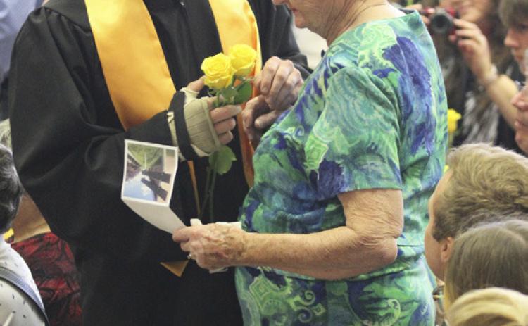 Tel Kvanvig delivers a yellow rose to his grandma Judy Ridenour. Gerri Peterson