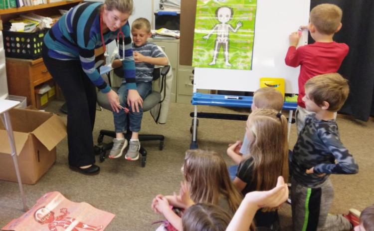 Dr. Alicia Ericksen tests Luke Cox’s reflexes. Donalee Barner
