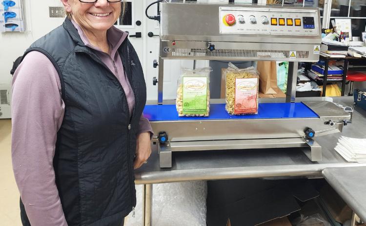 Deb Cox with the sealing machine she was able to purchase with part of her Mullen Commercial Club business grant. courtesy photo