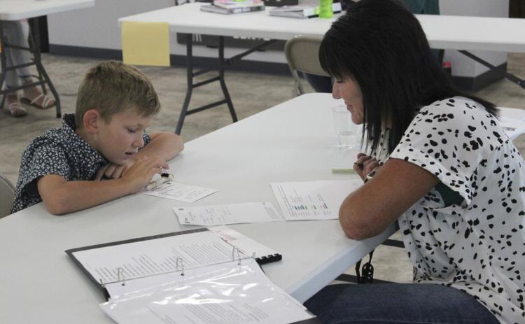 Cooper Phillips discusses his electricity project, a homemade flashlight, during 4-H interview judging last Thursday. Gerri Peterson