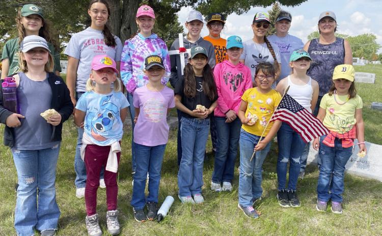 Girl Scouts and adult helpers who put crosses and flags on the veterans’ graves at the Cedarview Cemetery last Thursday are pictured back, l-r: Langston Pohlmeier-Fajardo, Mercedes Garner, Taylor Moore, Chloe Newman, Pandora Gray, Marci Roman, Mary Jo Walker, Nikki Gracey. Front: Tatum Deibler, Daryl Deibler, Danielle Peterson, Mia Roman, Logan Moore, Natalee Walker, Elle Gracey, Aislynn Connealy. Sooky Marks
