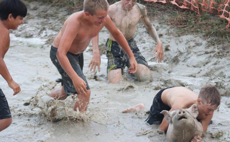 Gus Wingebach holds onto his team’s pig while the rest of his teammates head his way - Lorenzo Gonzalez, Caleb Deibler and Jedd Kraus - who had dove for the pig already! Gerri Peterson