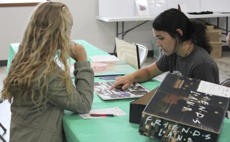 Izabella Brown discusses one of her 4-H entries with the judge. Gerri Peterson