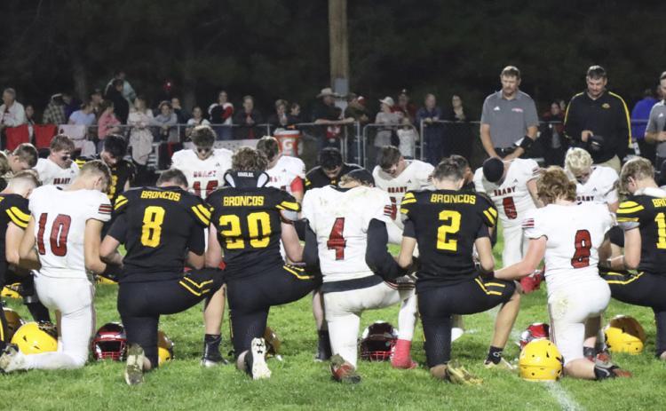 The Mullen Broncos and Brady Eagles gather to pray following the football game last Thursday. Gerri Peterson