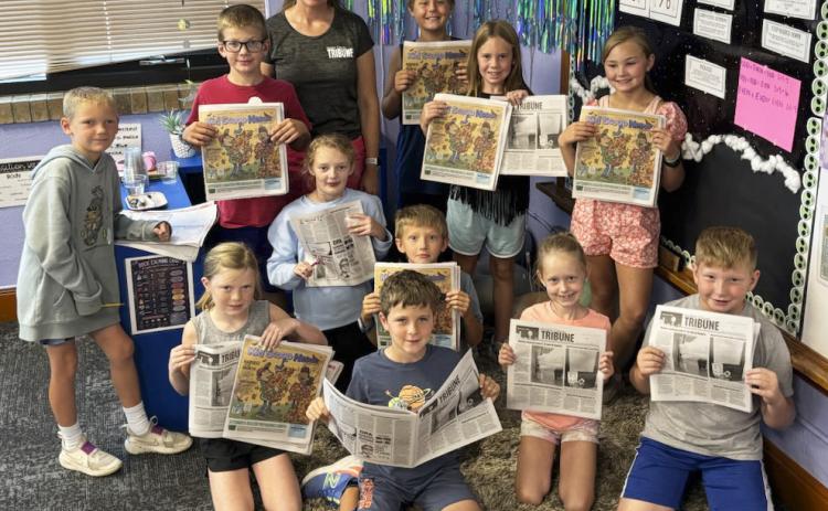 The Mullen third grade class is pictured with their copies of the Tribune and Kid Scoop News, standing, l-r: Jaxson Barnes, Cooper Ourada, Gerri Peterson of the Tribune, Kayden Evans, Kinley Crisp, Brogan Jewell. Kneeling: Meyer Vinton, Anna Ridenour, Tate Phillips, Merick Lattin, Aurora Polt, Harrison Vinton. Mollie Finney