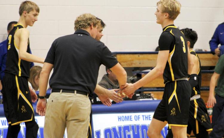 Alex Moore, Head Coach Brad Wright and Samuel Coble give high fives to Clayton Moore and Trevor Kuncl as they come off the court last Thursday at Hyannis. Shelby Welsh