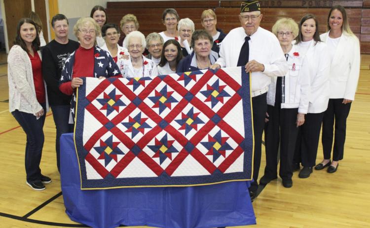 American Legion Auxiliary and Junior Auxiliary members are pictured with Marvin Cox and the Quilt of Valor made by Auxiliary member Doris Starr after the Memorial Day program on Monday. Pictured l-r: Rebekah Peters, Carol Wright, Doris Starr, Alysen Daniels, Jan Furrow, Mildred Szwanek, Winnie Cooley, Sherron Sullivan, Eva Crawford, Kalli Licking, Alice Phipps, Linda Cox, Kathie Hassett, Marvin Cox, Kathy Tuton, Kristi Daniels, Sue Licking. Gerri Peterson