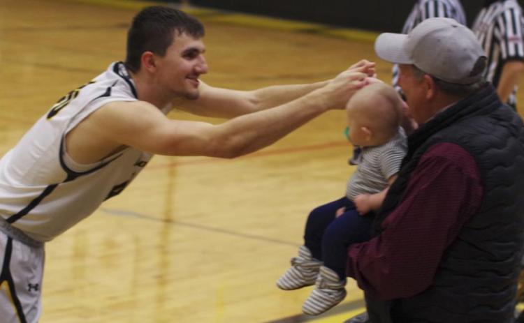 Senior Bryce McIntosh fist bumps his nephew, Chasin McIntosh, held by Bryce’s dad, Bernie, last week on Senior Night. Barb McIntosh