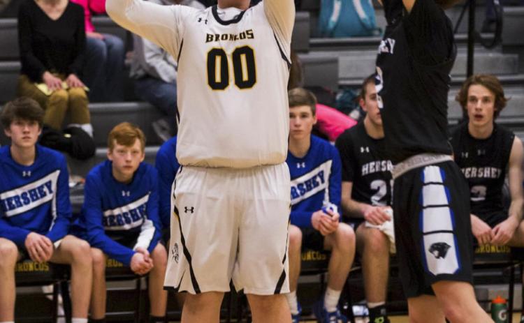Senior Cade Groseth puts up a three pointer last Tuesday against Hershey. Megan Andersen