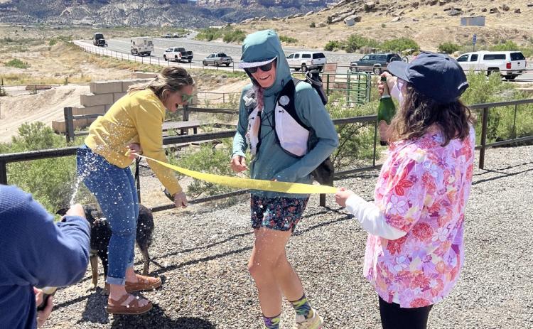courtesy photos Madison Tomlinson crosses her finish line with a champagne spray to be the first person to pioneer and complete a continuous loop around Colorado’s Grand Valley earlier this month.