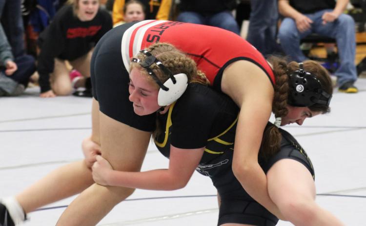 Kassidy Cheever competing in Oshkosh with her teammates cheering her on in the background. Joni Cheever