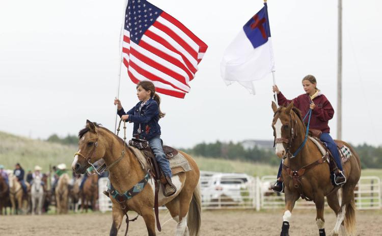 Mullen’s Finley Mundorf carries the American flag in the grand entry for the Sandhills Rodeo Bible Camp. Suzie Wahlgren