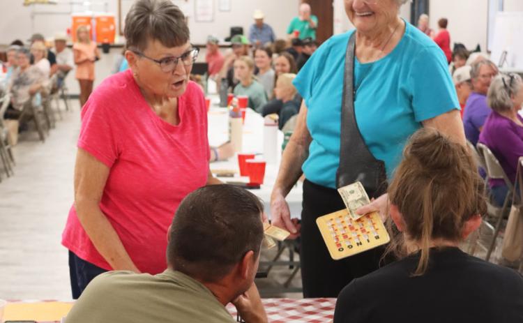 When Sue Bonesteel (left) and Judy Ridenour got Bingos at the same time, they opted to split the $20 pot instead of playing “name that tune” to determine one winner. Also pictured are Bingo callers Ryan and Shelby Ridenour. Gerri Peterson